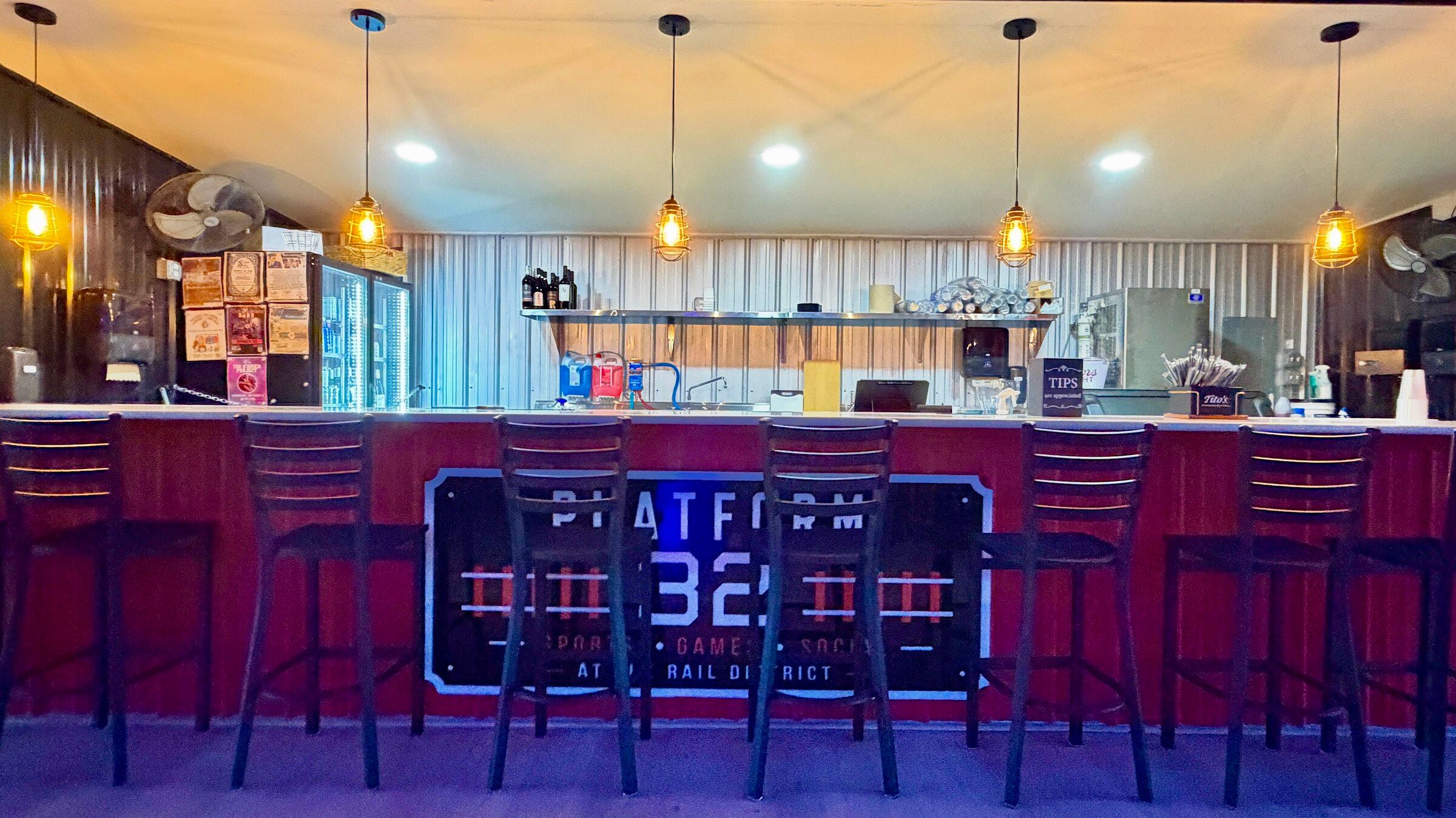 The Platform 32 bar, its backlit logo panel on the bar front and pendant lights above a row of stools